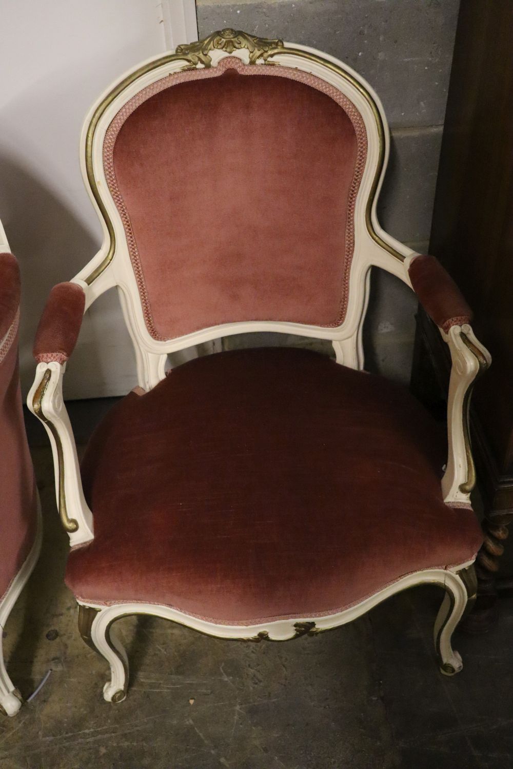 A Louis XV style cream and gilt painted carved wood framed canape and a pair of open armchairs, upholstered in pink dralon, settee widt